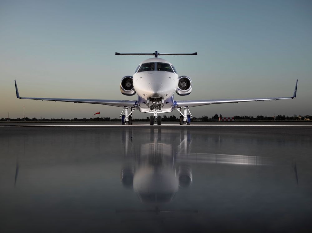 Sun rising over flying private jet wing